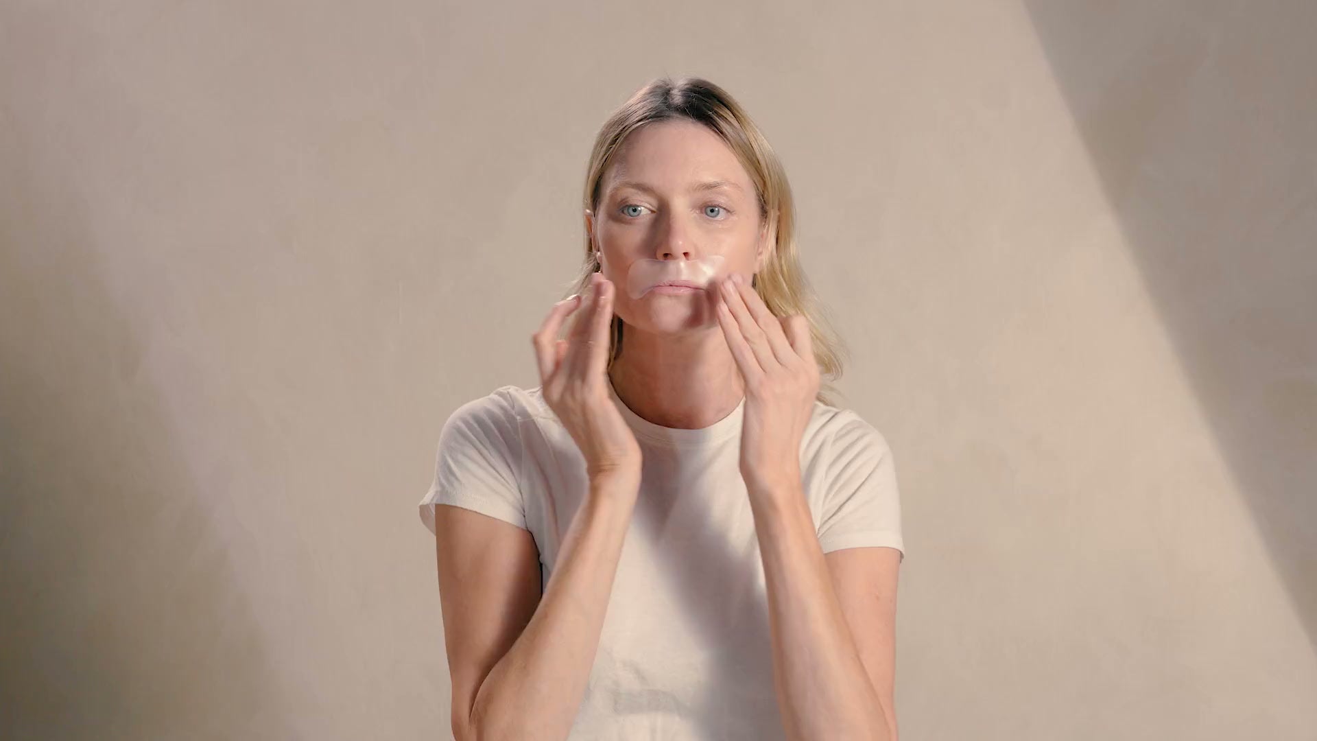 Woman touching her face after applying a smoothing patch